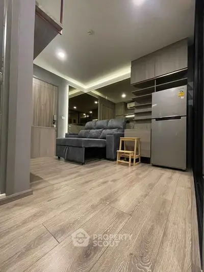 Modern living room with sleek wooden flooring and stylish furniture in a cozy apartment.