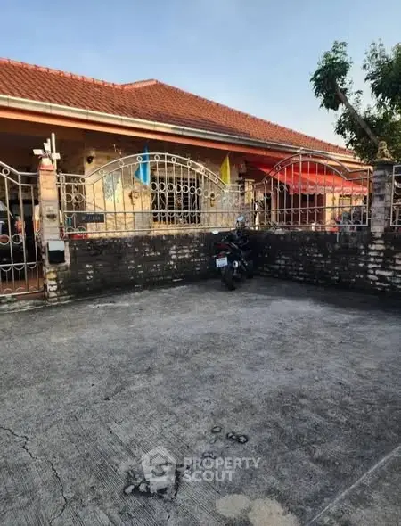 Charming single-story home with red-tiled roof and spacious front yard.