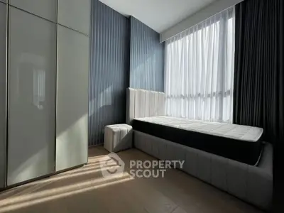 Modern bedroom with sleek design, featuring a single bed and floor-to-ceiling windows for natural light.