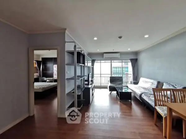 Spacious living room with modern furniture and natural light in a stylish apartment.