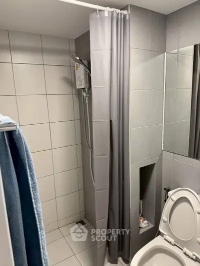 Modern bathroom with shower curtain and tiled walls in a sleek design.