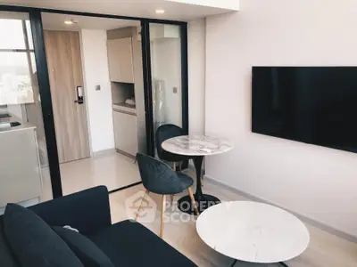 Modern living room with sleek furniture and wall-mounted TV in a stylish apartment.