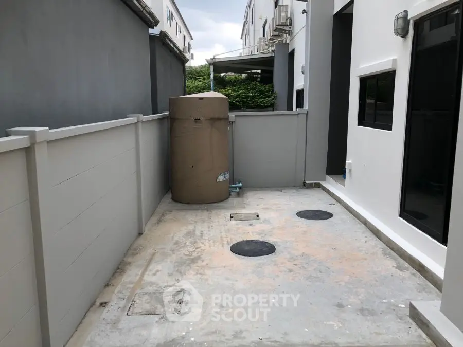 Modern exterior space with utility area and water tank in a contemporary home.