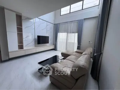 Spacious modern living room with high ceilings and elegant marble accents
