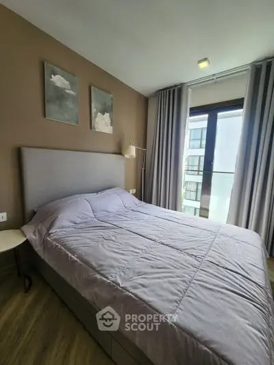 Modern bedroom with stylish decor and large window offering natural light and city view.