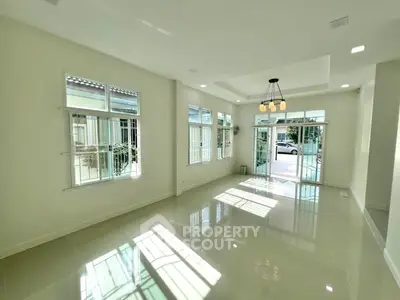 Spacious modern living room with large windows and glossy tile flooring