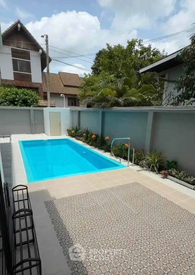 Charming backyard with a pristine swimming pool and lush garden, perfect for relaxation and entertainment.
