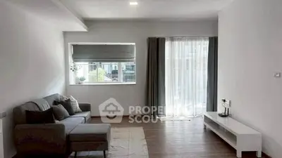 Spacious living room with modern decor and large window for natural light.