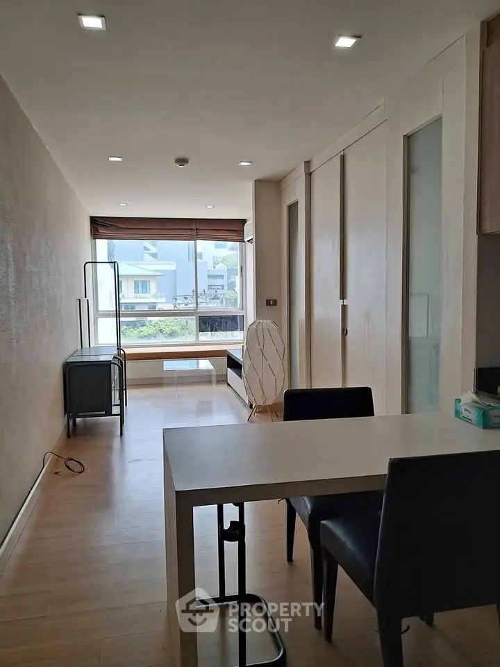 Modern apartment interior with sleek dining area and large window view