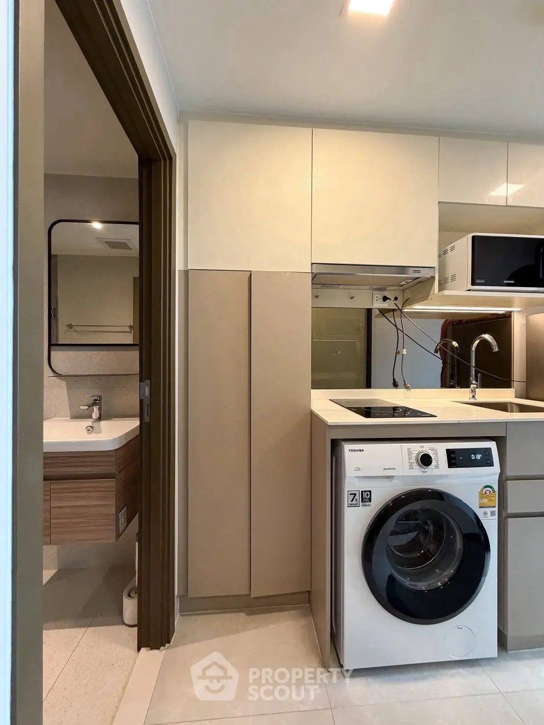 Modern compact kitchen with washing machine and sleek cabinetry