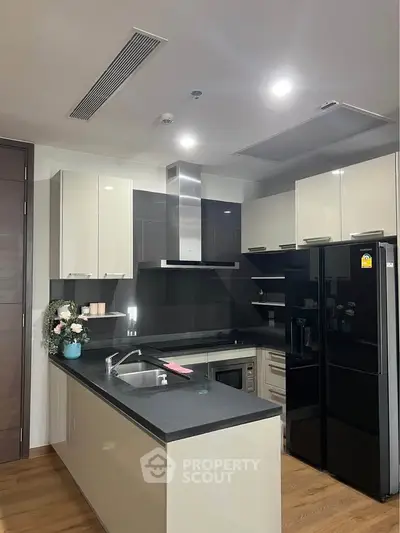 Modern kitchen with sleek cabinetry, island sink, and high-end appliances in a stylish apartment.