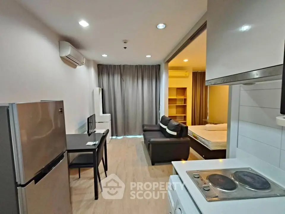 Modern studio apartment with open layout, featuring a cozy living area and compact kitchen.