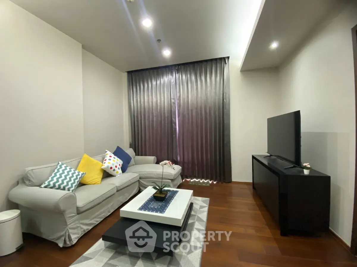 Modern living room with cozy sofa, stylish decor, and flat-screen TV, perfect for relaxation.