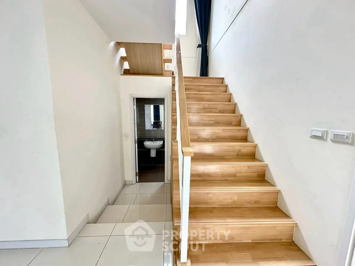 Modern staircase with wooden steps and sleek design in a contemporary home interior.