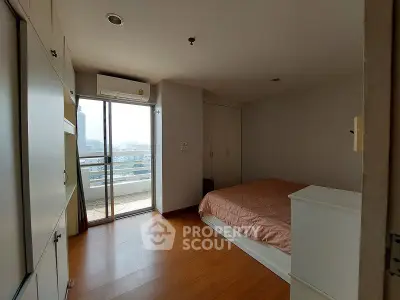 Cozy bedroom with balcony access and ample natural light in modern apartment.