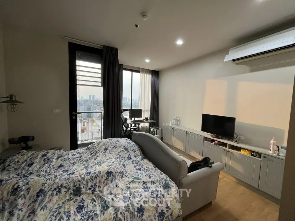 Cozy bedroom with city view, modern furnishings, and natural light