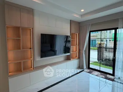 Modern living room with built-in shelves and large window offering natural light and garden view.