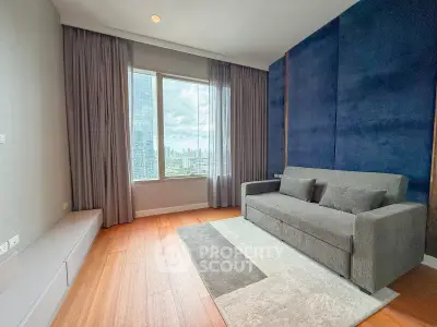Modern living room with city view, featuring a sleek gray sofa and elegant wooden flooring.