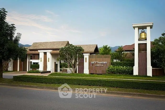 Elegant entrance of a modern residential building with lush greenery and clear skies.