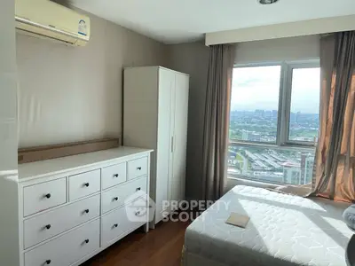 Bright bedroom with city view, featuring white furniture and large window.