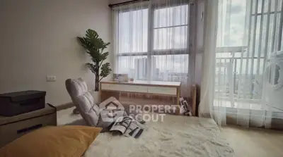 Cozy living room with plush carpet and panoramic city view from large windows.