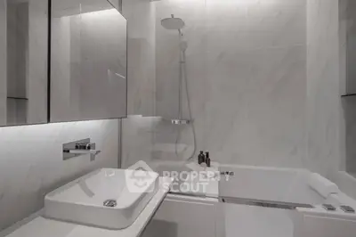 Modern bathroom with sleek design, featuring a bathtub and stylish fixtures.