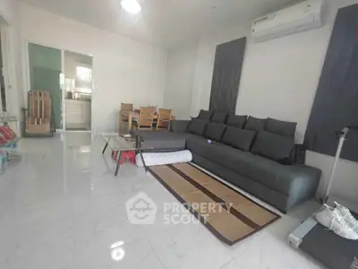 Spacious living room with modern gray sofa and sleek air conditioning unit, perfect for relaxation.