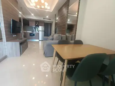 Modern open-plan living room with stylish furniture and sleek kitchen appliances.