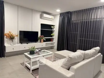 Modern living room with sleek furniture and large TV, perfect for relaxation.