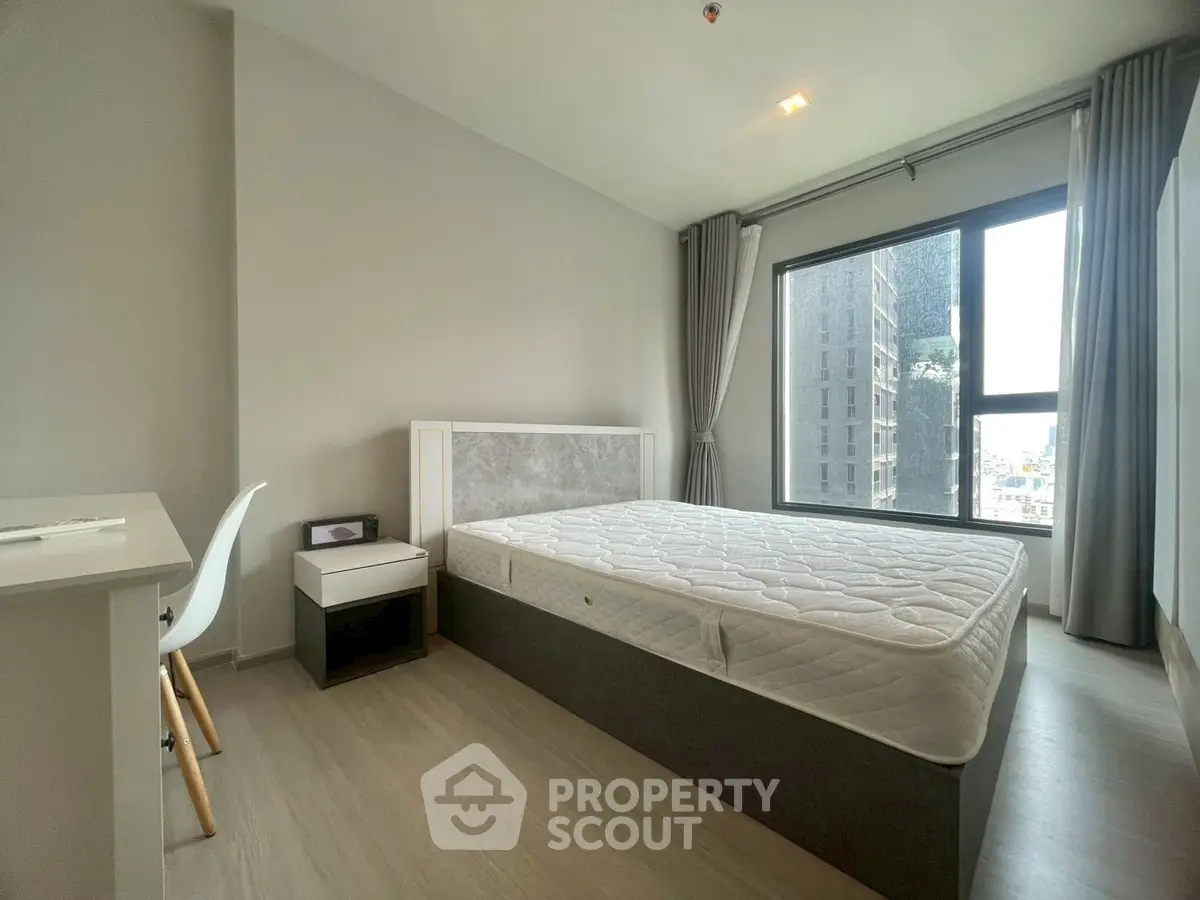 Modern bedroom with large window and minimalist furniture in urban apartment