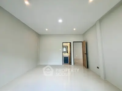 Spacious empty room with modern lighting and tiled flooring, ready for customization.