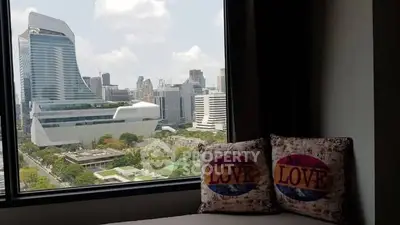 Stunning cityscape view from a modern apartment window with cozy seating area.