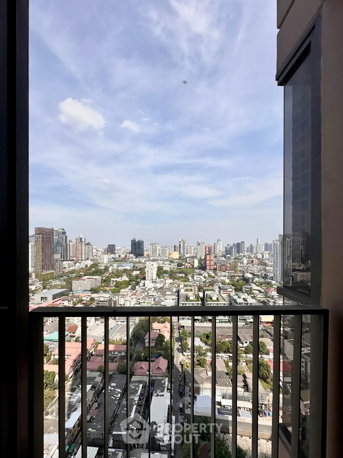 Stunning cityscape view from a high-rise balcony, showcasing urban skyline and vibrant city life.