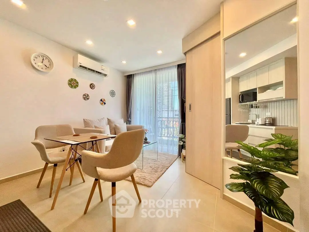 Modern living room with dining area and balcony view, featuring stylish decor and natural light.