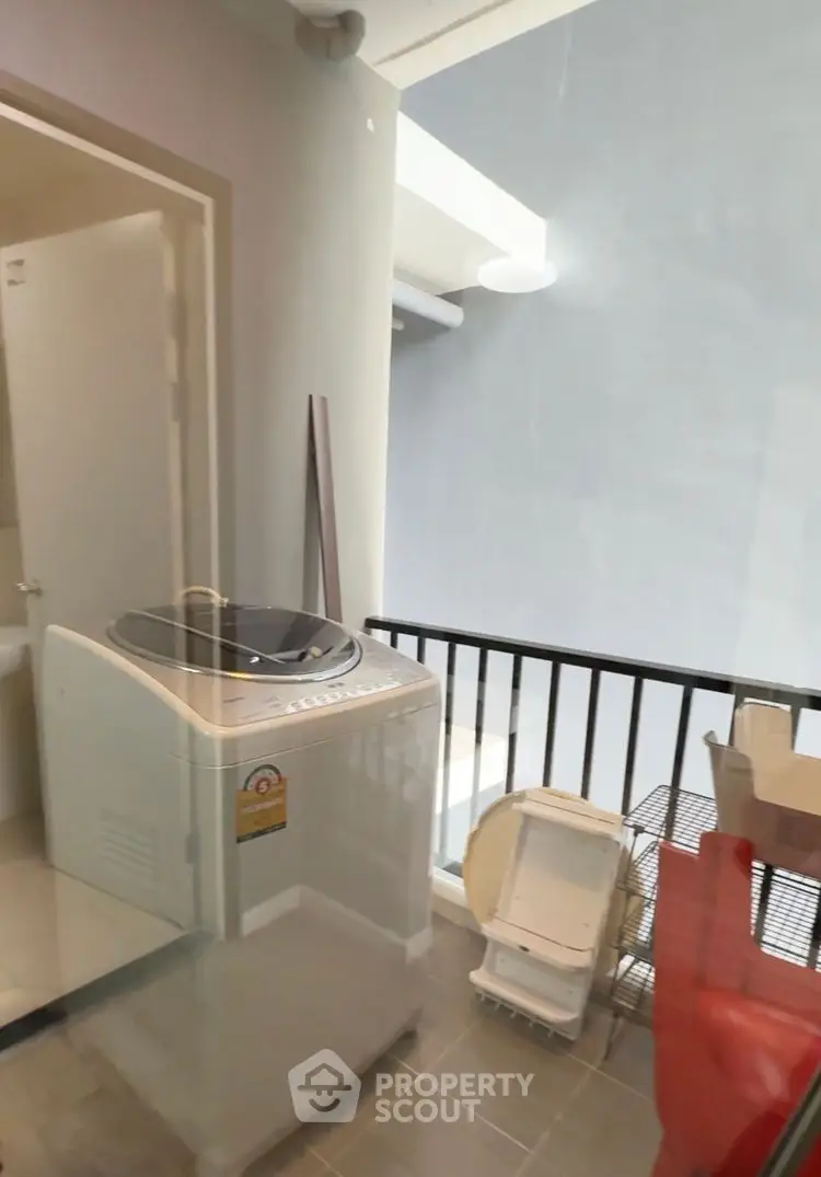 Compact laundry area with washing machine and balcony view