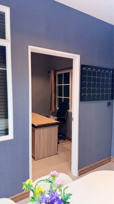 Modern home office with sleek desk and chair, featuring a wall calendar and stylish decor.
