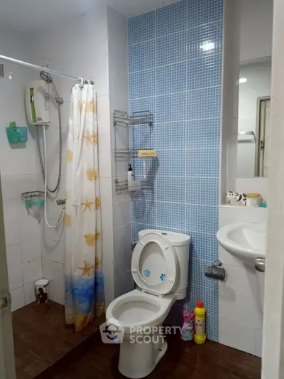 Cozy bathroom with shower and modern fixtures, ideal for compact living spaces.