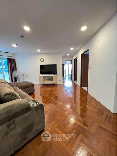 Spacious living room with polished wooden floors and modern furniture