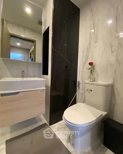 Modern bathroom with sleek design and elegant fixtures, featuring a stylish sink and toilet.