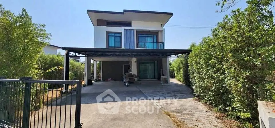 Modern two-story house with spacious driveway and lush greenery