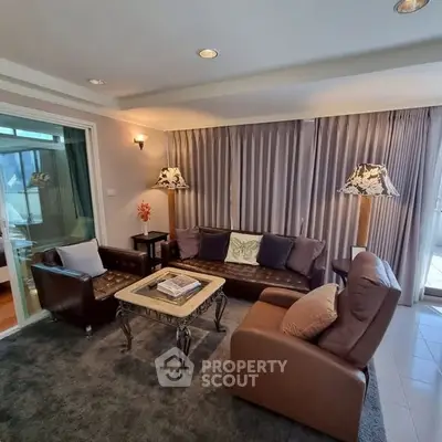 Spacious living room with elegant decor and natural light, featuring cozy seating and stylish lighting.