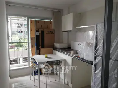 Modern kitchen with balcony view, featuring sleek cabinetry and compact dining area.
