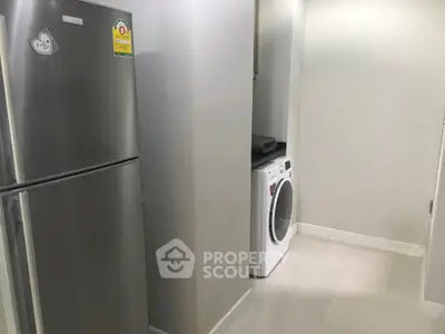 Modern laundry area with stainless steel fridge and washing machine