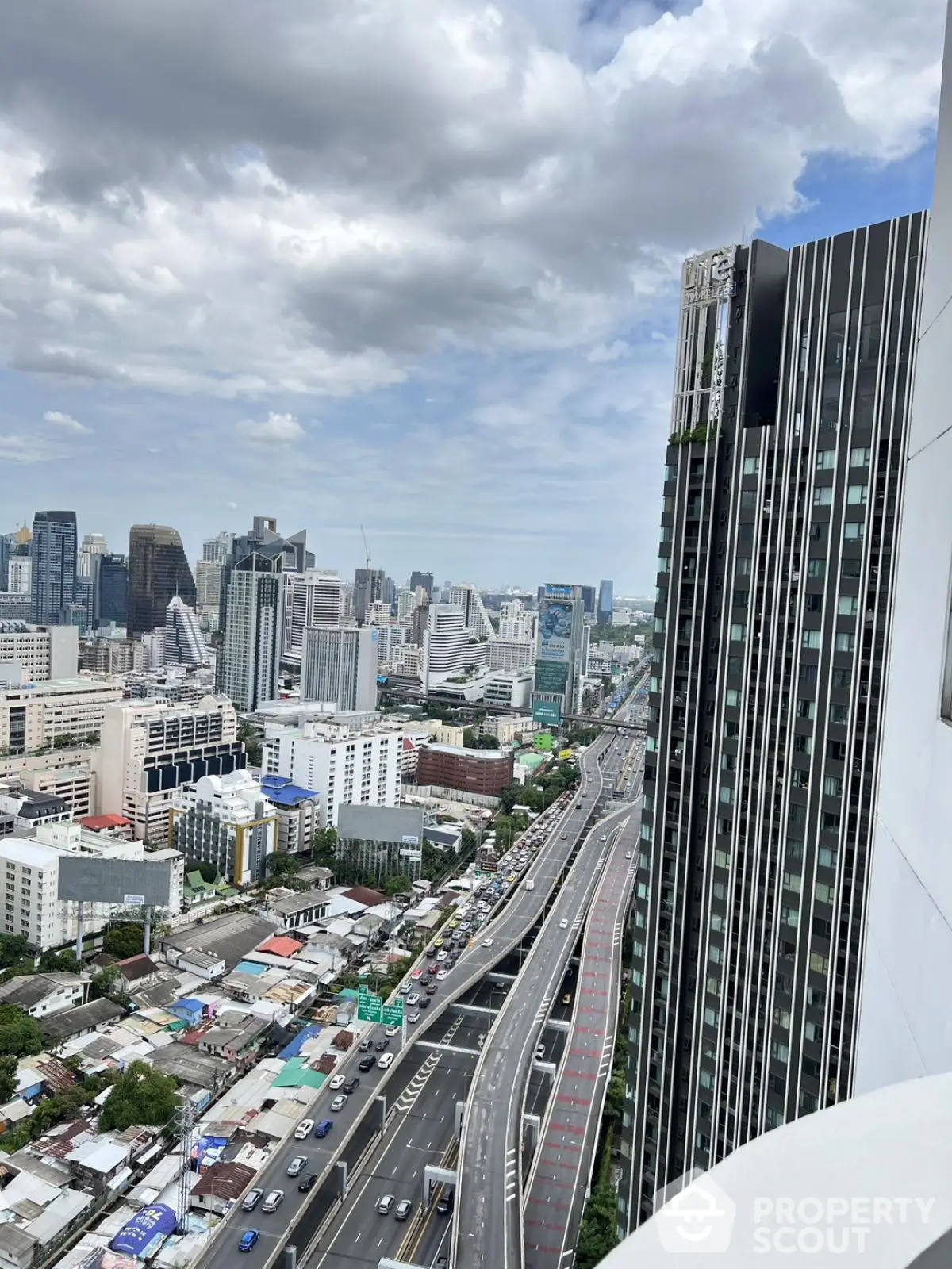 Stunning cityscape view from a high-rise building showcasing urban skyline and busy highway.