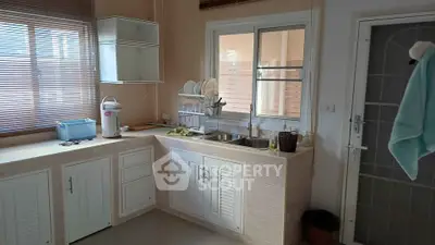 Charming kitchen with ample natural light, featuring a sleek countertop and modern dish rack.