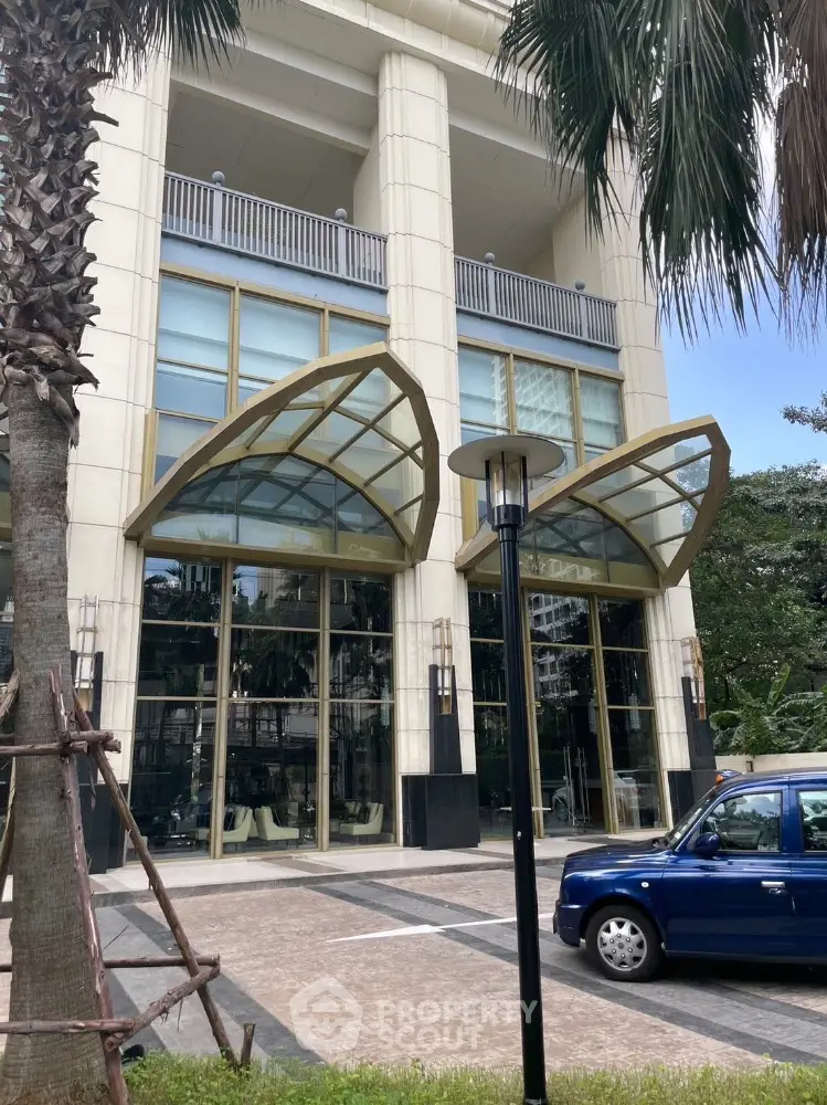 Luxurious building entrance with modern glass canopy and elegant architecture