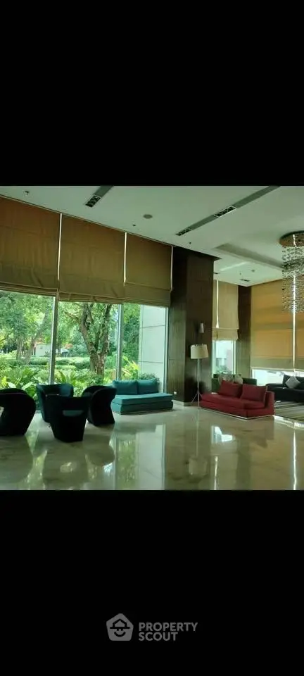 Luxurious lobby with modern seating and large windows overlooking lush greenery.