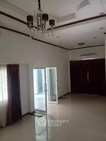 Spacious living room with elegant chandelier and sliding glass doors