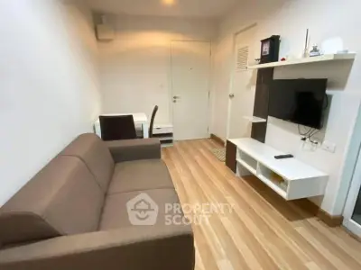 Cozy living room with modern furniture and wall-mounted TV in a compact apartment.