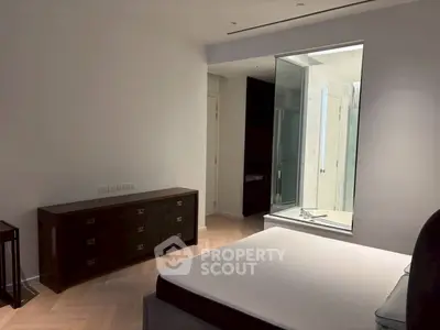 Modern bedroom with elegant design and glass-enclosed bathroom for luxurious living.